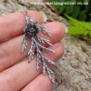 Sterling silver cedar leaf & seed necklace held in hand with natural background