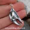 reverse of sterling silver crab claw pendant with silver belcher chain held in hand on natural stone background