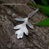 back of sterling silver hawthorn leaf with bark background