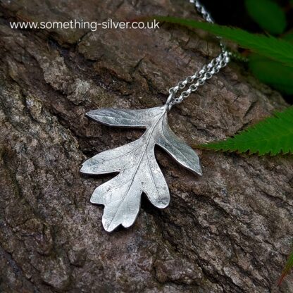 back of sterling silver hawthorn leaf with bark background