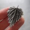 Sterling-silver-stinging-nettle-pendant-in-hand-back